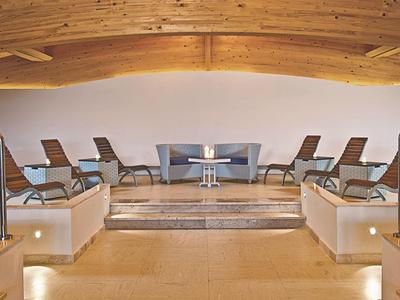 Eleganter Ruheraum mit Liegestühlen und warmem Holzdekor in einem Wellnessbereich.