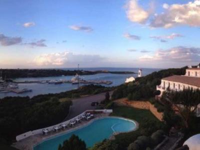 Panoramablick auf Hotel mit Pool und Meer im Hintergrund bei Sonnenuntergang.