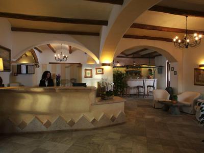 Gezellig hotel lobby met receptiebalie, zitplaatsen en warm licht.