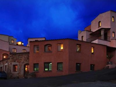 Groothoekweergave van een verlicht hotel bij schemer in een landelijke omgeving.