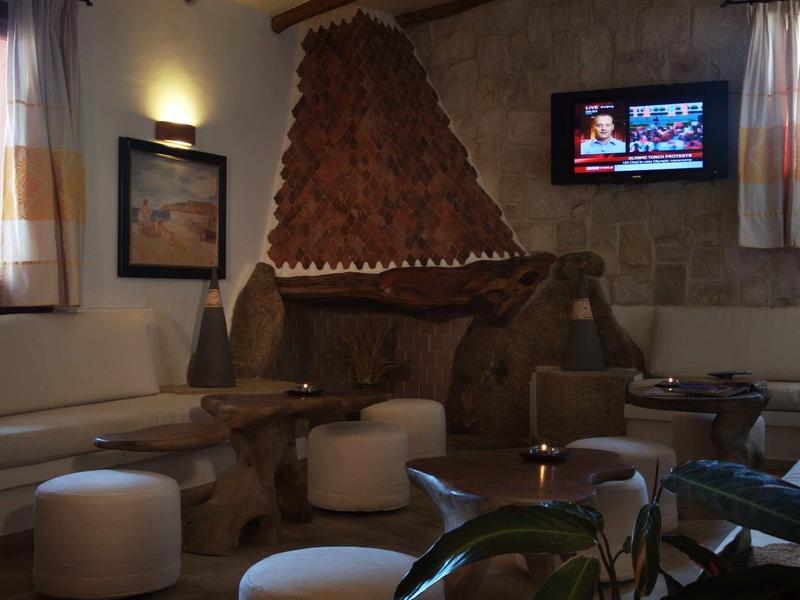 Gezellige hotel lounge met bruinkleurige open haard, comfortabele zitplaatsen en warme verlichting.