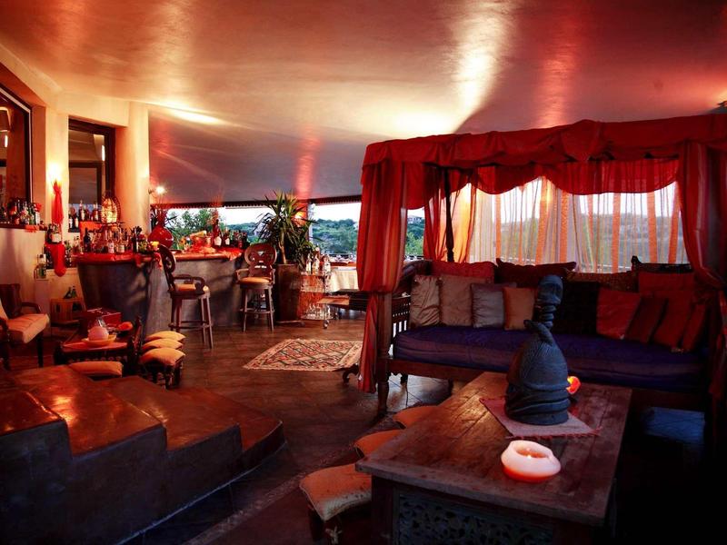 Stanza d'hotel arredata con stile, illuminazione accogliente e aree salotto di notte.