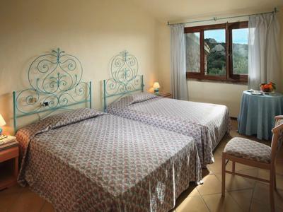 Hotelový pokoj se dvěma samostatnými lůžky, stolem s ovocem a otevřeným oknem s výhledem.