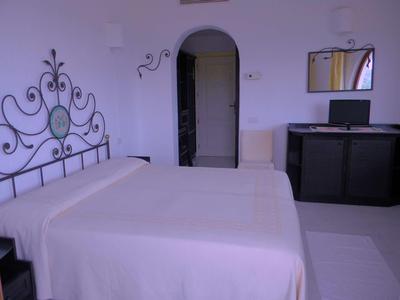 Camera da letto con letto grande, testiera decorativa e scrivania con computer