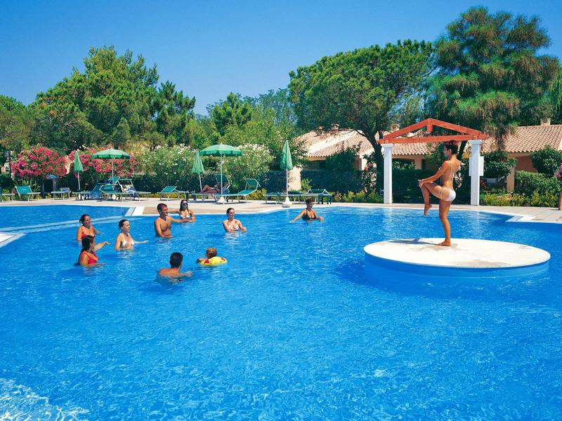 Großes rundes Schwimmbecken mit mehreren Menschen und einem Bademeister auf einer Plattform.