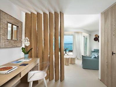 Bright hotel room with sea view, wooden partition, and desk