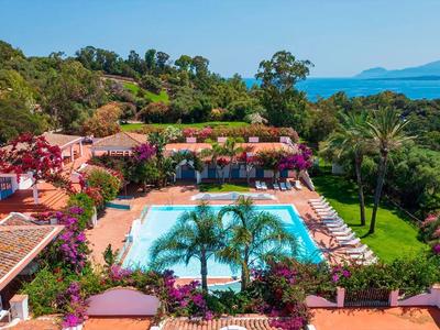 Beautiful outdoor pool surrounded by lush garden, overlooking hills and the sea.