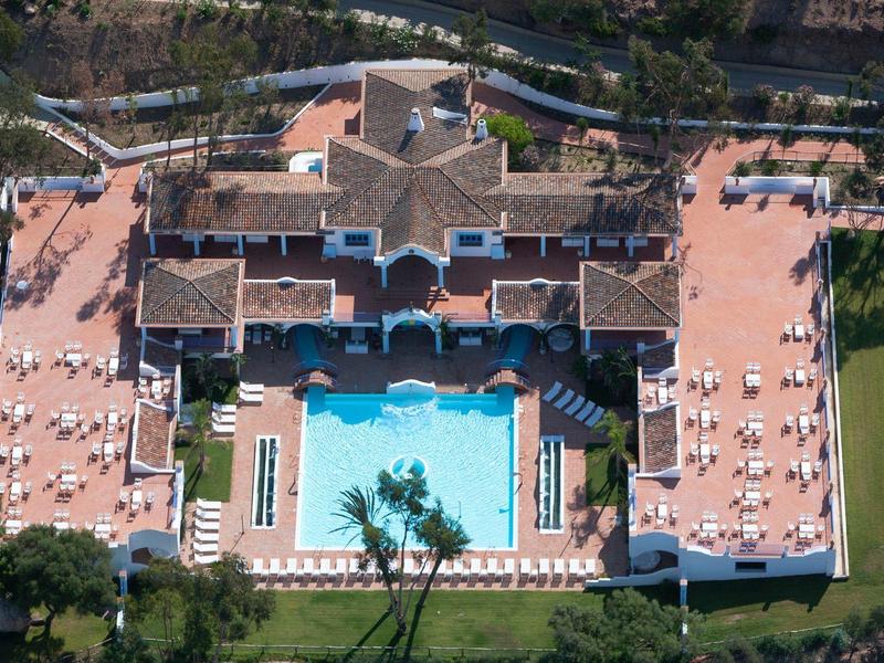 Aerial view of a large hotel with a central swimming pool and sunbathing areas.