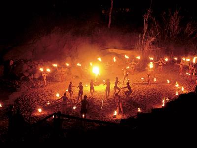 Night scene with people around campfires in open area