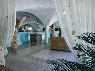 Hotel-lounge met gebogen plafonds, zitgedeelte en tropische planten