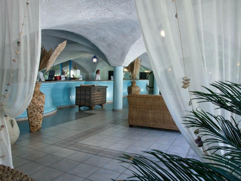 Hotel-lounge met gebogen plafonds, zitgedeelte en tropische planten