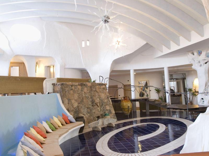 Luminoso atrio d'hotel con design moderno, panca comoda e pavimento blu decorativo.