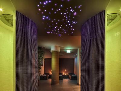 Lounge dell'hotel con illuminazione soffusa e luci a forma di stelle sul soffitto.