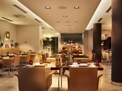 Ristorante elegante con illuminazione calda, mobili in legno e tavoli apparecchiati in un hotel.