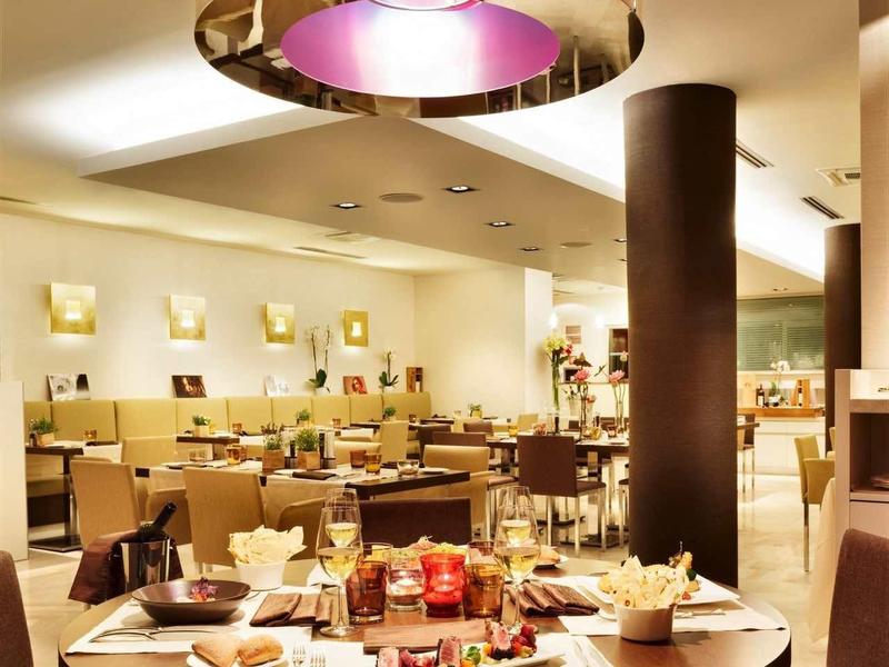 Ristorante elegante con luce calda, tavolo rotondo in legno e sedie comode.