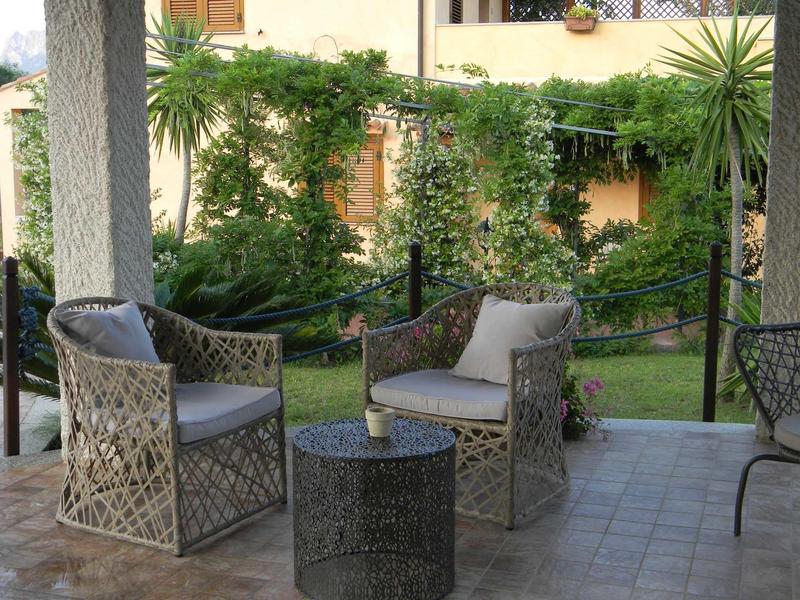 Cozy garden furniture on paved terrace overlooking lush garden