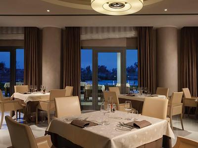 Elegancka sala śniadaniowa z nakrytymi stołami i wygodnymi krzesłami, zmierzch na zewnątrz.