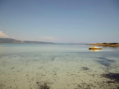 Eau peu profonde claire avec un bateau jaune et un vaste ciel près de la côte.