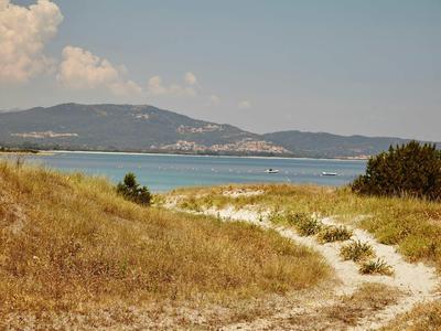 Chemin sablonneux à travers les dunes avec vue sur la mer et le paysage en arrière-plan