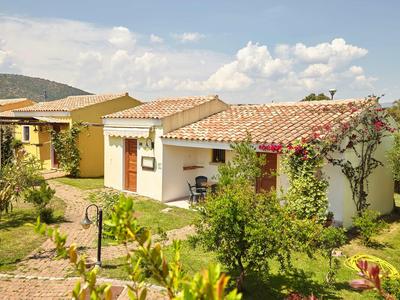 Une petite maison de vacances avec un toit en tuiles rouges et un jardin en milieu rural.