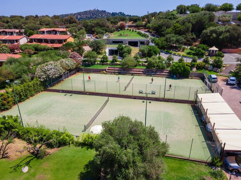 Vue d'un complexe hôtelier avec plusieurs courts de tennis et verdure environnante
