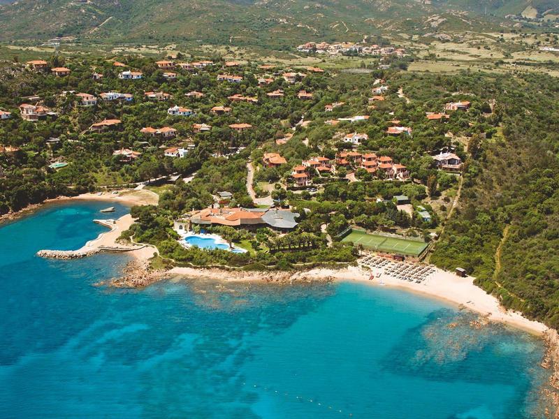 Luchtfoto van een kustresort met zwembad, stranden en helder blauw water.