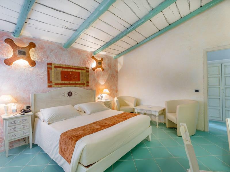 Gezellige slaapkamer met tweepersoonsbed, blauwe plafondbalken en moderne inrichting.