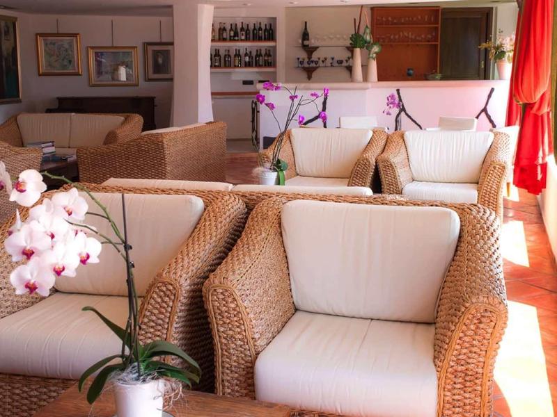 Pohodlný posezení s proutěnými křesly a dekorativními orchidejemi v teple osvětlené místnosti.