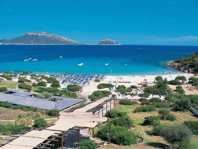 Pohled na písečnou pláž s modrým mořem a ostrovy v pozadí