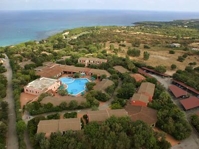 Letecký pohled na resort s bazénem, obklopený zelení a blízko moře.