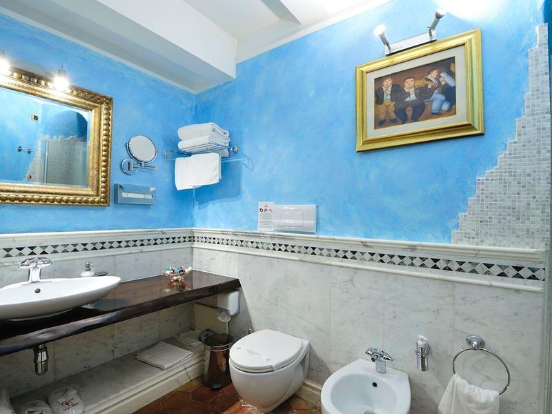 Moderne badkamer met blauw geschilderde muren, toilet, bidet en wastafel.