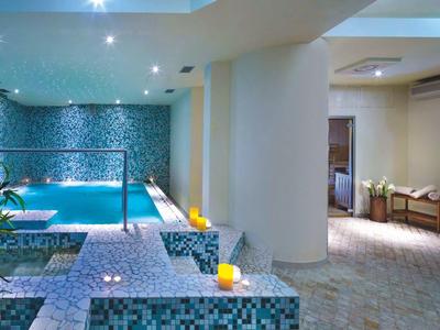 Moderner Innenpoolbereich mit blauen Akzenten und gemütlicher Beleuchtung in einem Hotel.