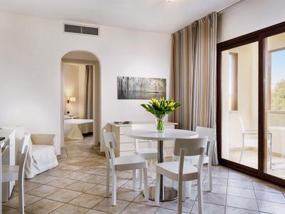 Hell eingerichteter Wohnbereich mit Esstisch, Stühlen und Blick auf Balkon mit Naturblick.