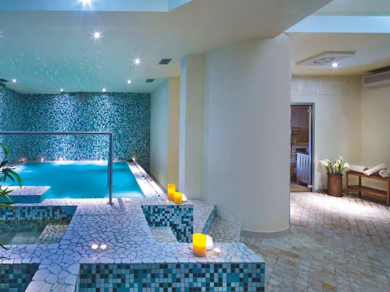 Moderner Innenpoolbereich mit blauen Akzenten und gemütlicher Beleuchtung in einem Hotel.