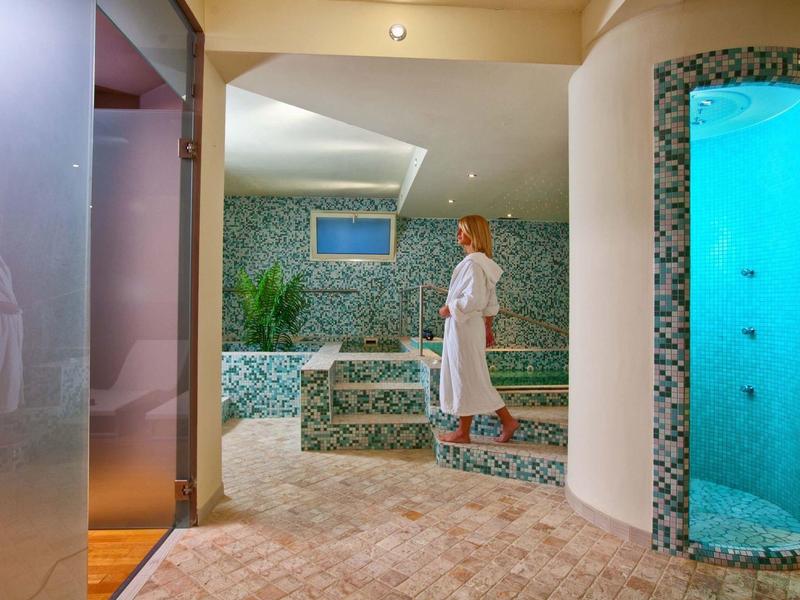 Moderne Wellnessoase mit Dampfbad, Mosaikfliesen und entspannter Atmosphäre.