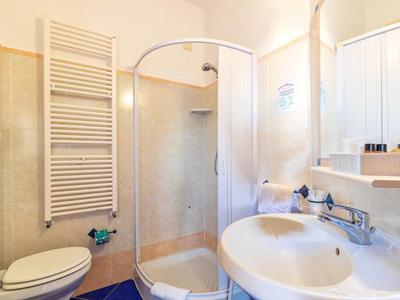 Bright bathroom with shower, sink, toilet, and heated towel rack.