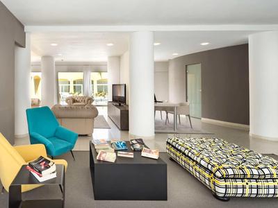 Modern living room with colorful seating and minimalist design.