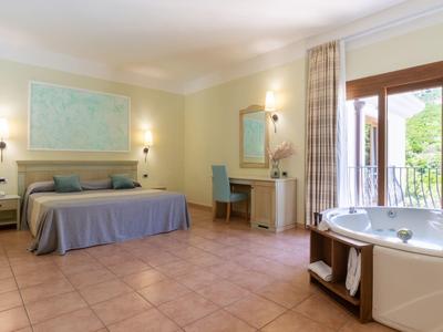 Camera luminosa con letto matrimoniale, scrivania, balcone e vasca autonoma.