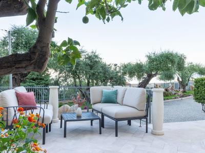 Accogliente lounge all'aperto con mobili imbottiti e tavolo su una terrazza del giardino.