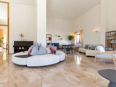 Světle moderní obývací prostor s kulatou bílou pohovkou a dřevěnou podlahou