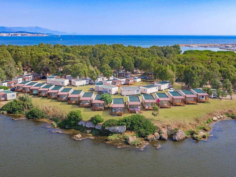 Station balnéaire avec bungalows entourés de forêt et d'eau.