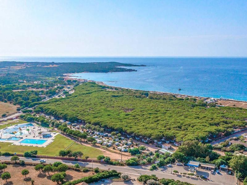 Luftaufnahme eines Küstenhotels mit Pool, Wäldern und Meer im Hintergrund.