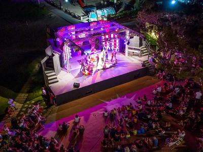 Buitenterras met live muziekoptreden en publiek in de nacht.