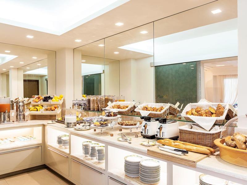 Jasna stacja bufetowa z wypiekami, płatkami i sokami w restauracji hotelowej.