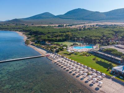 Pláž s lehátky, bazénem a horami v pozadí za jasného dne