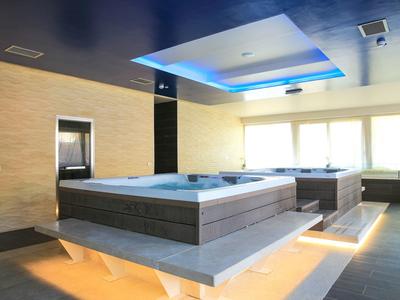 Moderne wellnessruimte met verwarmde bubbelbaden en sfeerverlichting.