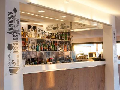 Moderne bar met verlichte planken vol flessen en houten accenten.