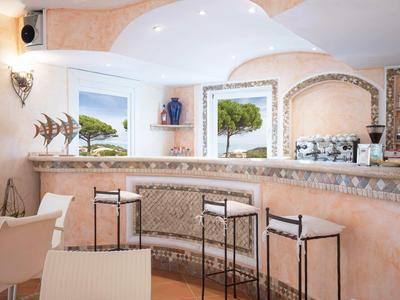 Bright bar area with built-in counter, modern seating, and windows overlooking greenery.