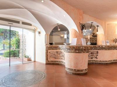 Elegant hotel lobby with tiled reception desk and arched windows.