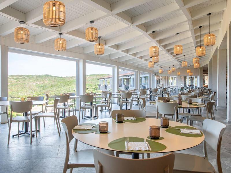 Helles, modernes Restaurant mit großen Fenstern und ländlicher Aussicht.